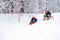 Children sliding down the snow path