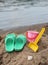 Children slippers and toys on beach