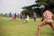 Children in a soccer practice match guided by school game coach. Boy kicks off the football