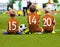 Children Soccer Team Playing Match. Football Game for Kids. Young Soccer Players Sitting on Pitch. Little Kids in Blue and Orange