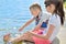 Children splash their feet in the water of the lake.