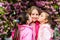Children spring garden. Sakura garden. Sisters friends sakura trees background. Kids pink flowers of sakura tree