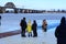 Children stand on the ice of a frozen river and watch the winter swimming. Winter sport and hardening. Dnipro city