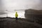 Children, standing at the edge of the ocean on rain day near Dyrholaey, watching the huge waves, Iceland wintertime