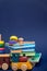 Children storybooks, wood toys, puzzle color train wagons stand on dark blue background