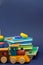 Children storybooks, wood toys, puzzle color train wagons stand on dark blue background