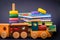 Children storybooks, wood toys, puzzle color train wagons stand on dark blue background