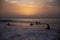 Children surf, a group of young surfers catching waves on sunset time. Surfing and sport lifestyle, outdoors activities
