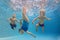 Children swim and dive underwater with fun in swimming pool