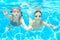 Children swim in pool under water, happy active girls in goggles have fun, kids sport