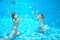 Children swim in pool underwater, girls have fun in water,