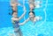 Children swim in pool underwater, happy active girls have fun under water