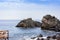 Children swim in the sea near rocks of the Cyclops, sea stacks in Acitrezza, Catania, Sicily, Italy