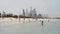 Children swim in the sea on a sandy beach Sufouh against the backdrop of skyscrapers in Dubai, UAE. Clear Sunny day 16