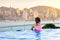 Children swimming in roof top outdoor pool on family vacation in Hong Kong. City skyline from infinity pool in luxury hotel in