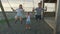 Children swing on a swing in the street at sunset.