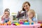 Children with teacher play colorful clay toy