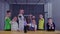 Children and teacher shows thumbs up holding glass globe over Tesla coil