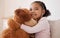 Children, teddy bear and girl with a child hugging her stuffed animal with a smile in her house. Kids, happy and safe