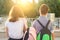 Children teenagers go to school, back view. Outdoors, teens with backpacks