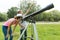 Children teenagers in the park looking through a telescope