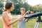 Children teenagers with telescope look at the sky in nature