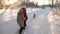 Children teens travel in winter in the park with a dog. two girls and dog and dog walk along path in winter park