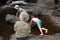 Children and their grandmother playing in the brook