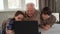 Children and their grandpa watching something on laptop