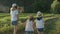 Children three girls in hats holding hands running back along the rural country road