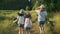 Children three girls in hats holding hands running back along the rural country road