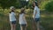 Children three girls in hats holding hands walking back along the rural country road