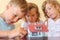 Children three together looking at model of house