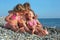 Children three together sitting on stony beach