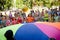 Children throw ball together using multicolored linen