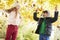 Children Throwing Leaves In Autumn Garden