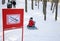 Children are tobogganing near prohibiting sign