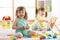 Children toddler and preschooler girls play logical toy learning shapes, arithmetic and colors in kindergarten or