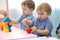 Children toddlers play colorful clay toy in kindergarten