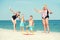 Children together with their mother and grandmother playing a game throwing rings on the beach