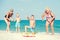 Children together with their mother and grandmother playing a game throwing rings on the beach