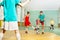 Children training football in school sports hall