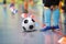 Children training soccer futsal indoor gym. Young boy with soccer ball training indoor football. Little player in light blue sport