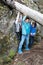 Children trying to lift tree trunk in forest