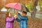 Children under umbrella enjoy to autumn rain