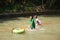 Children in the village play cheerful water slides on the river,