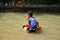 Children in the village play cheerful water slides on the river,