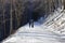 Children on a walk. View of a snowy forest road.