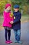 Children walking in beautiful autumn park on warm sunny fall day.