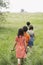 Children Walking On Grassy Field